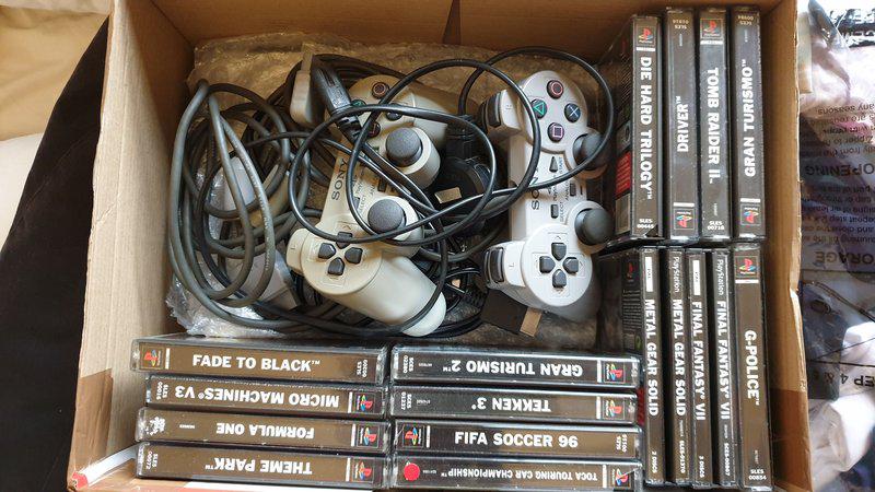 My initial collection of games in a box along with two Dualshock controllers.