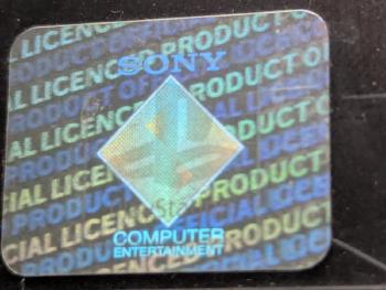 Close-up of a genuine Hologram A, with soft diagonal background text sitting behind the logo.