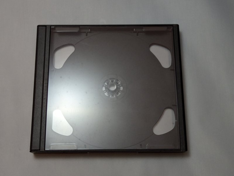 Front face of the mini black bordered PAL jewel case, showing the black plastic border on the sides and the clear front panel.