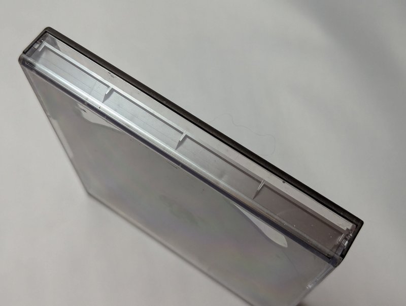 Side profile of the mini jewel case showing the clear spine edge and the black border running along the top.