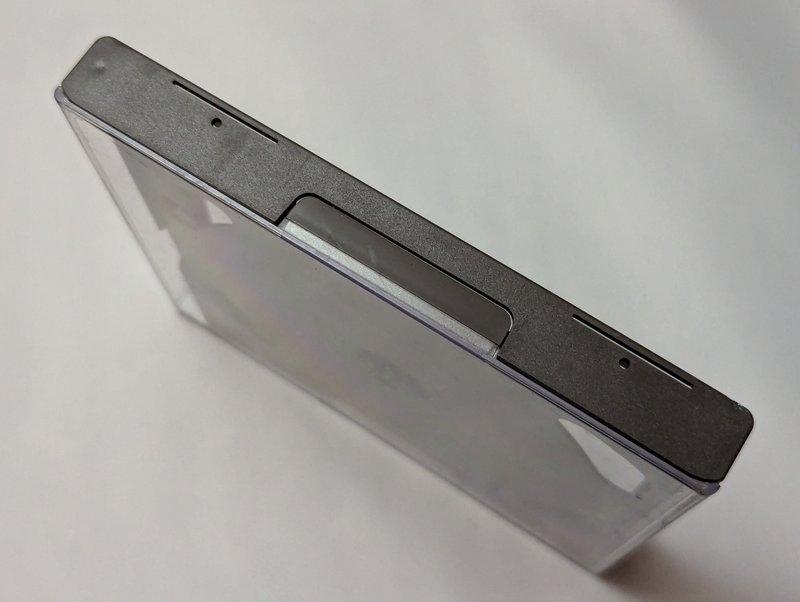 Alternate view of the top edge showing the latch and the black plastic border that forms the structural frame of the case.
