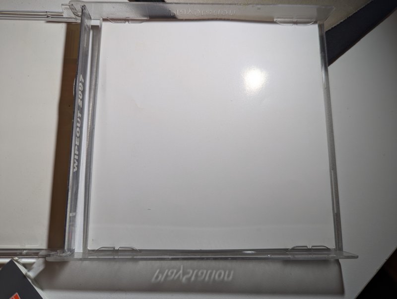 Comparison of the mini jewel case alongside a standard full PAL jewel case showing the height difference.