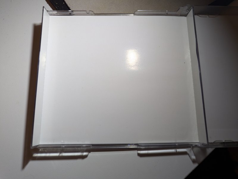 Second comparison view showing the mini jewel case next to a standard full PAL jewel case from above.